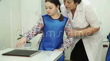一位年迈的护士正在为一个小女孩准备X光刷。